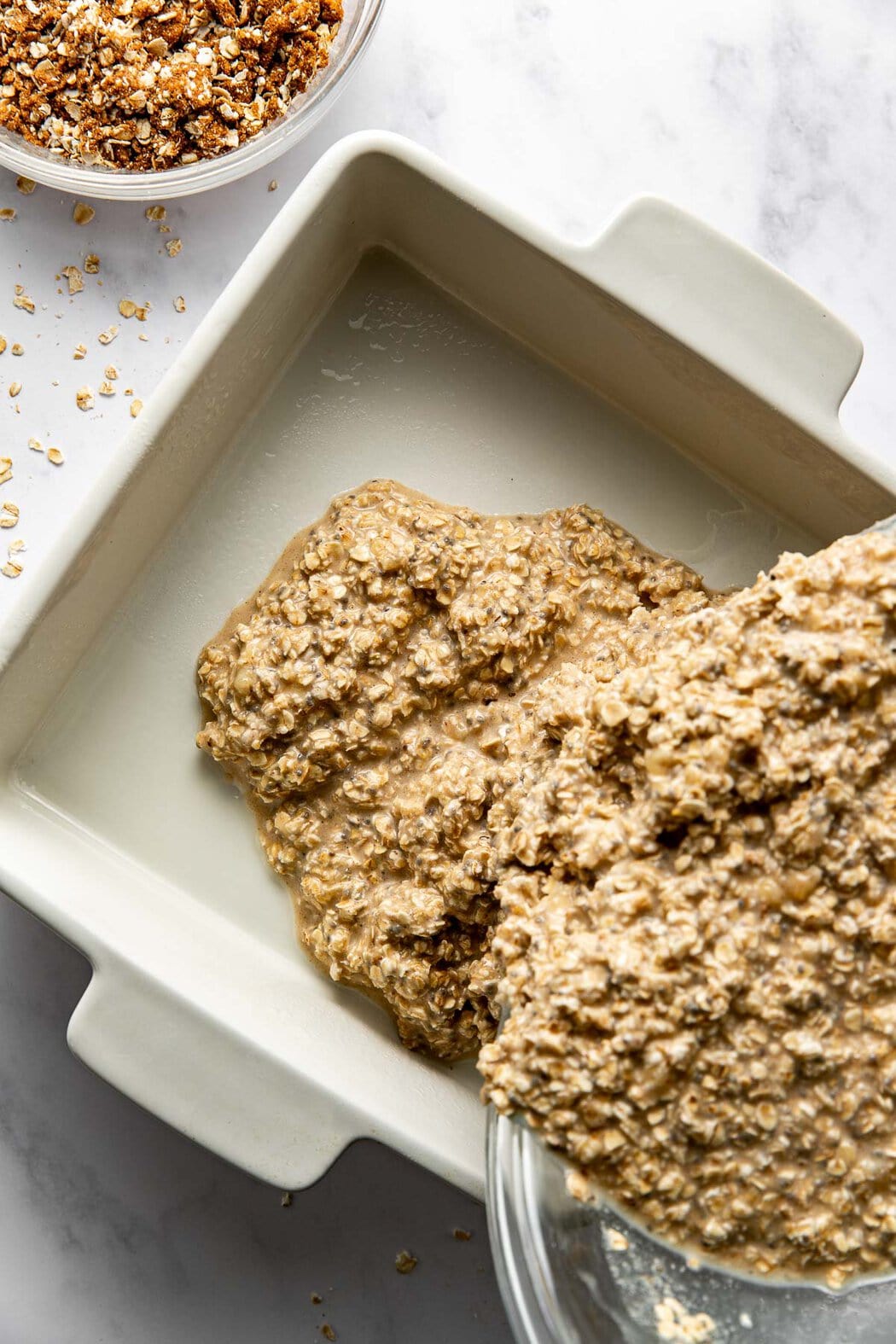 Cinnamon Streusel-Topped Baked Oatmeal batter being poured into a baking dish. 