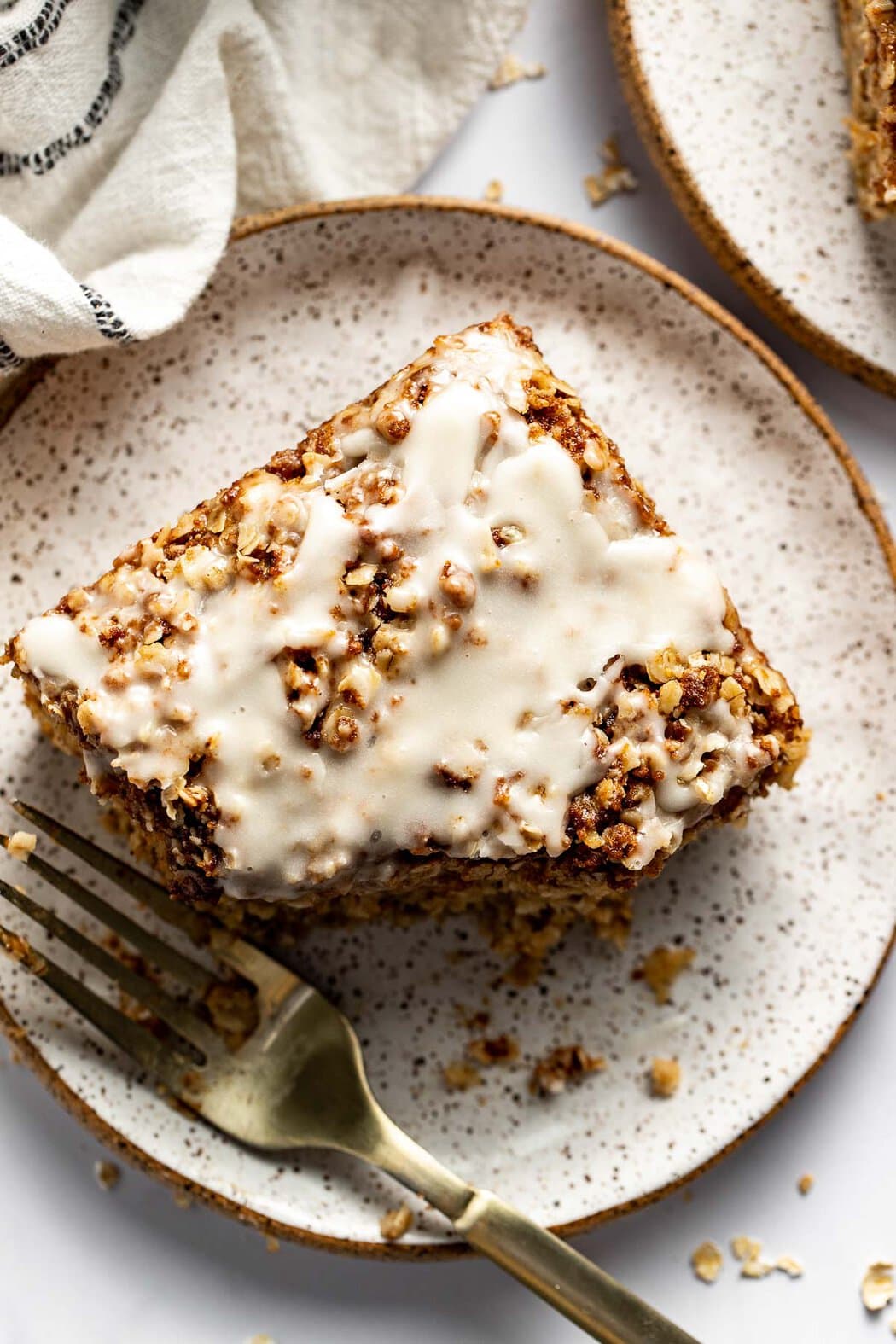 Overhead view of a plate of Cinnamon Streusel-Topped Baked Oatmeal with a fork for eating. 