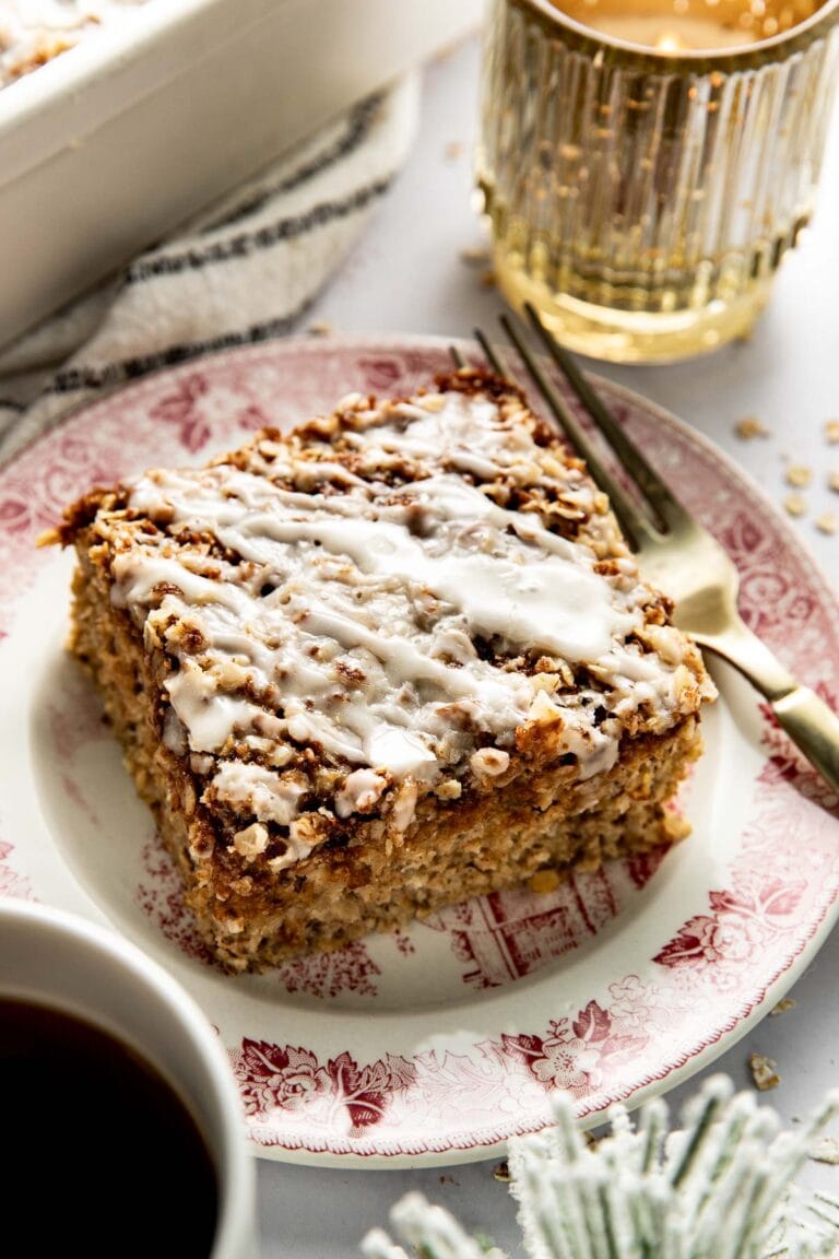 Close up view of a square piece of cinnamon streusel baked oatmeal topped with a white icing drizzle. 