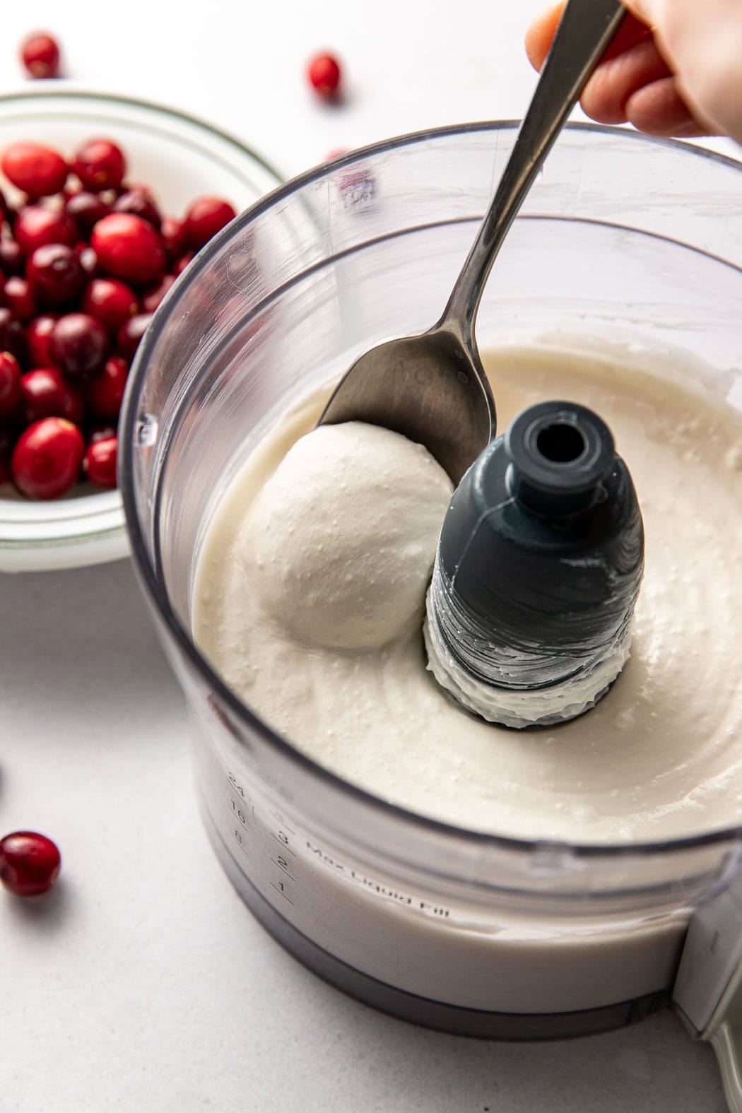 Overhead view of a food processor filled with smooth whipped cottage cheese and cream cheese. 