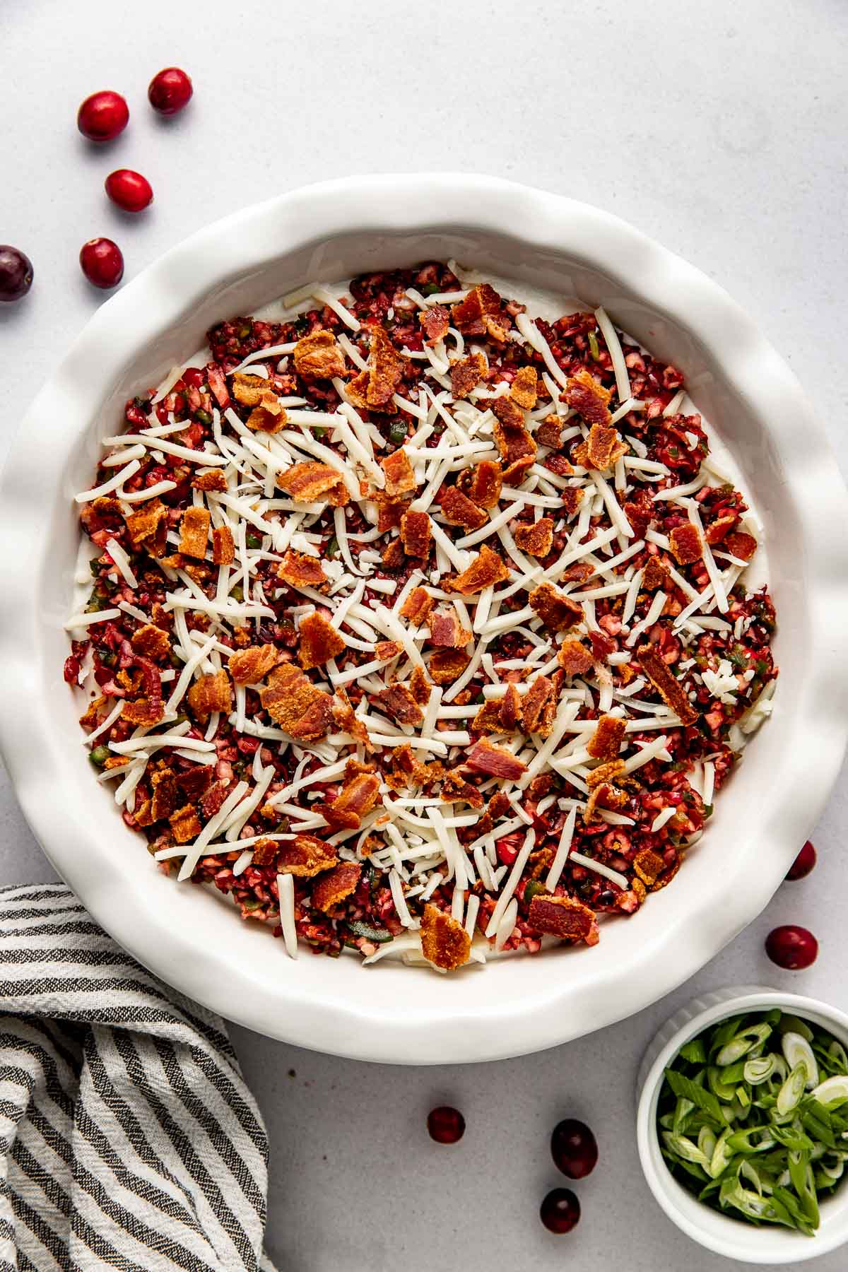 Overhead view of a freshly arranged dish of Cranberry Jalapeño Dip (With Whipped Cottage Cheese) ready to be baked in the oven. 