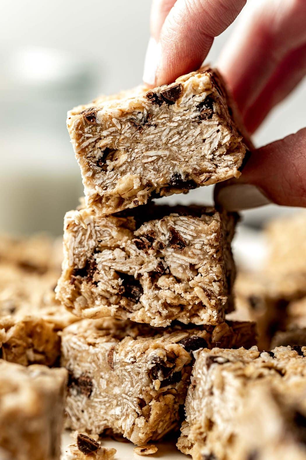 Close up view of a hand stacking squares of Copycat Heavenly Hunks. 