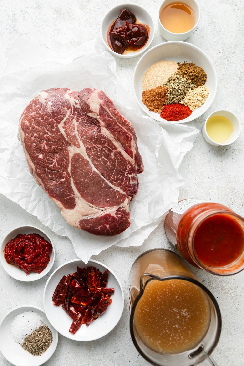 Overhead view of a variety of ingredients for Crockpot Birria Tacos (Quesabirria). 