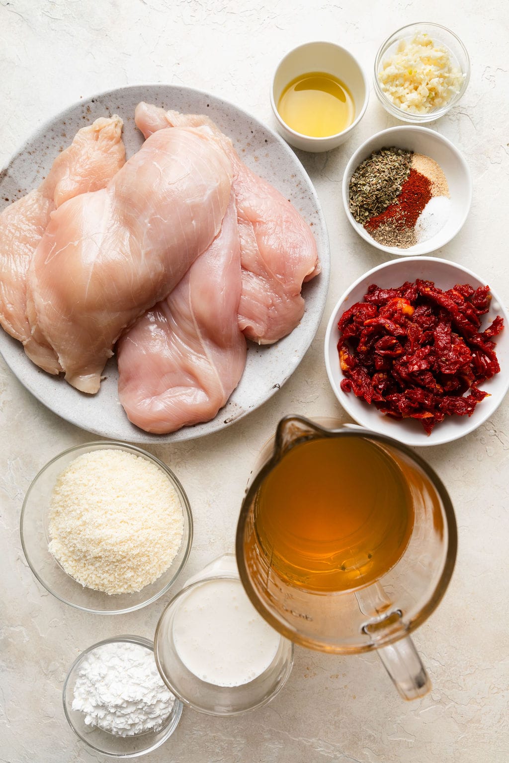 Overhead view of a variety of ingredients for Crockpot Marry Me Chicken in different sized bowls. 