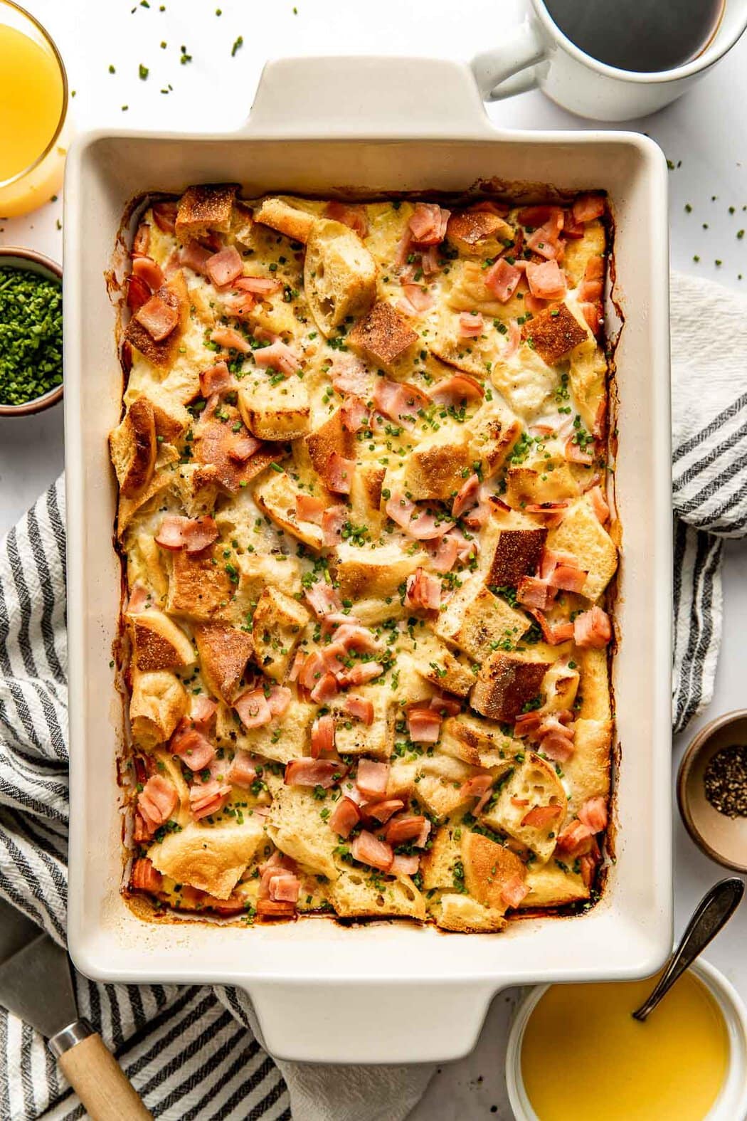 Overhead view of a freshly baked pan of Eggs Benedict Casserole topped with fresh chives. 