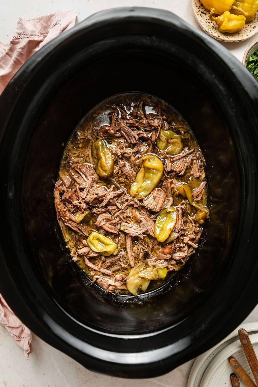 Overhead view of a slow cooker filled with finished Slow Cooker Mississippi Pot Roast. 