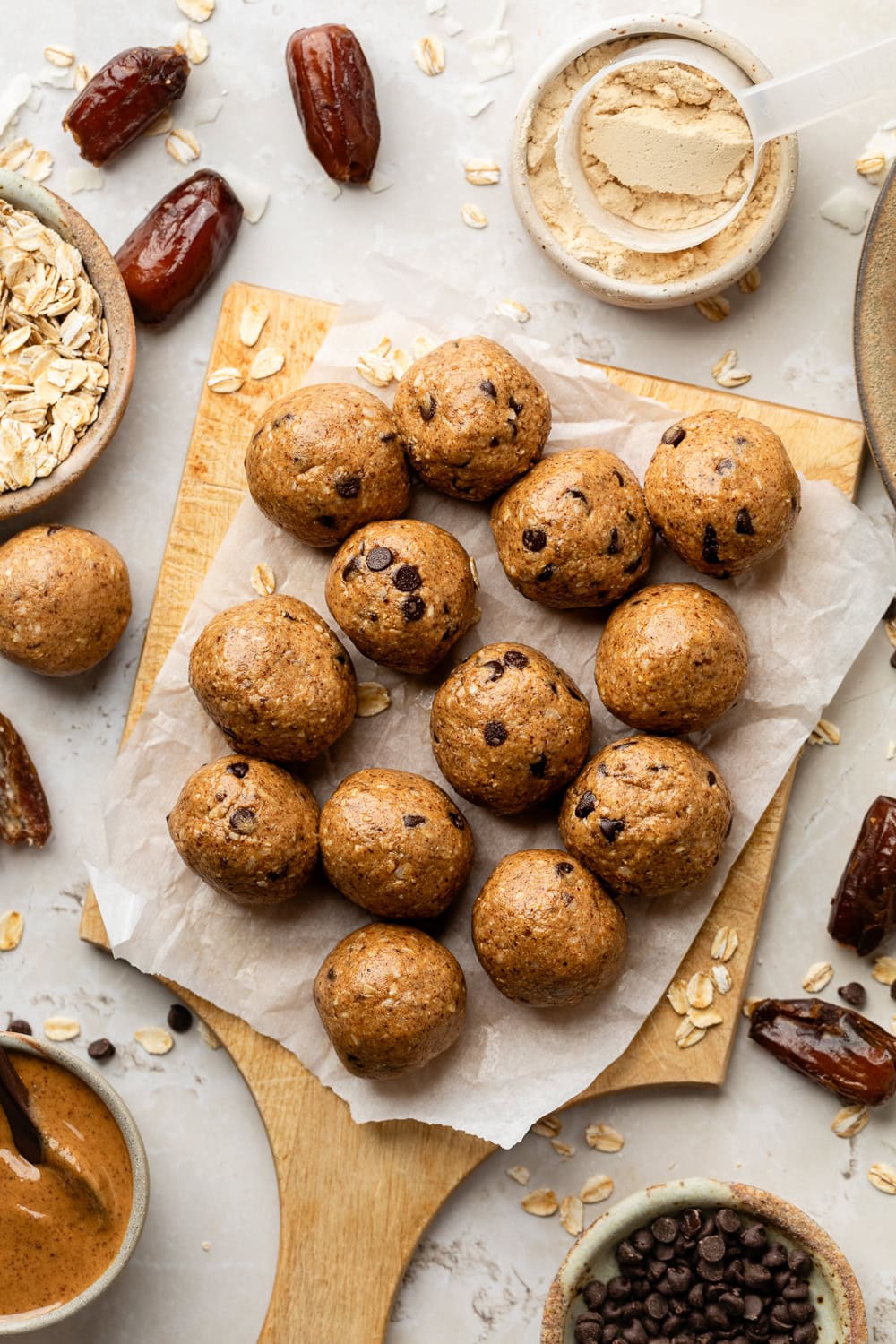 Close up view of freshly rolled Almond Butter Protein Balls on parchment paper. 