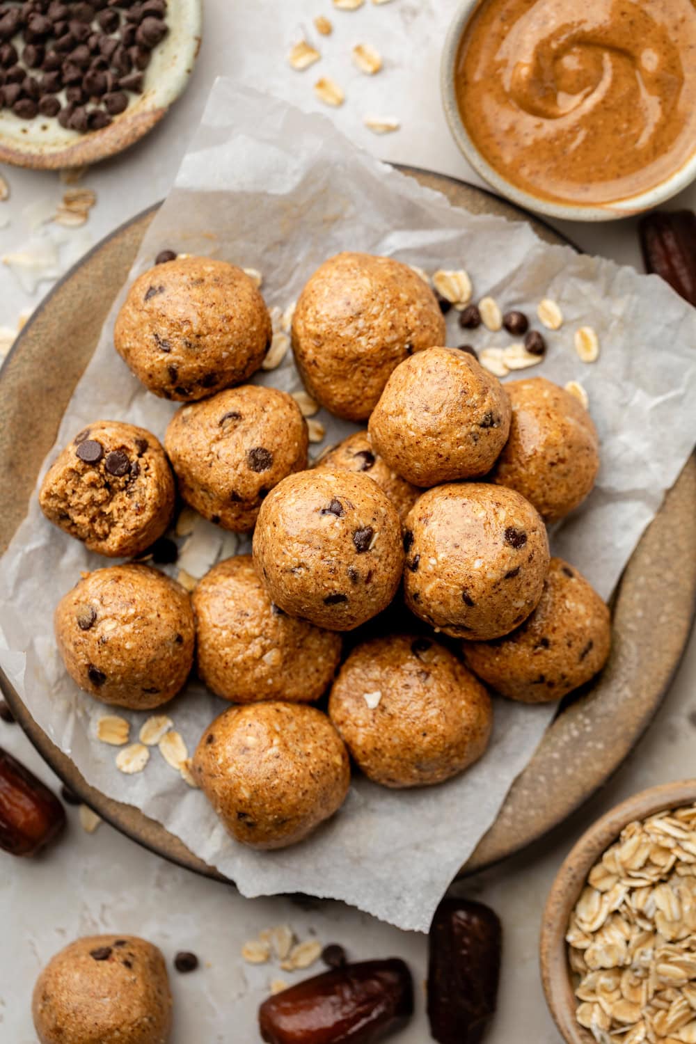 Overhead view of a plate of Almond Butter Protein Balls with mini chocolate chips. 