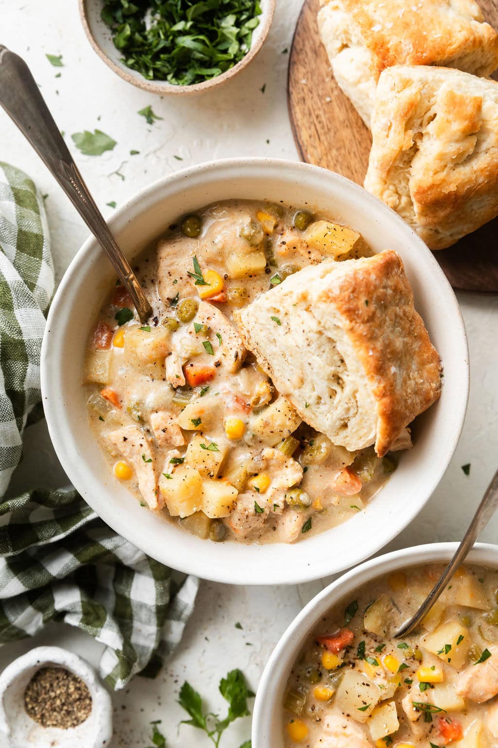 Overhead view of a bowl of Slow Cooker Chicken Pot Pie Soup with a biscuit on the side. 