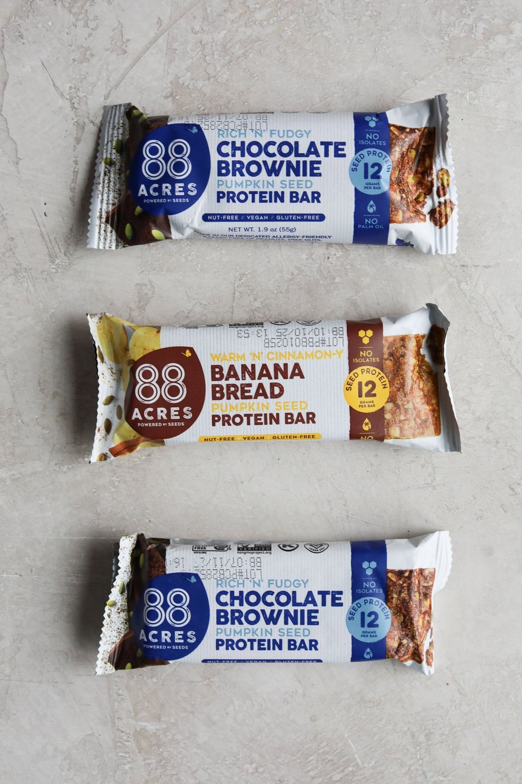 Three 88 Acres Protein Bars on a light grey background.