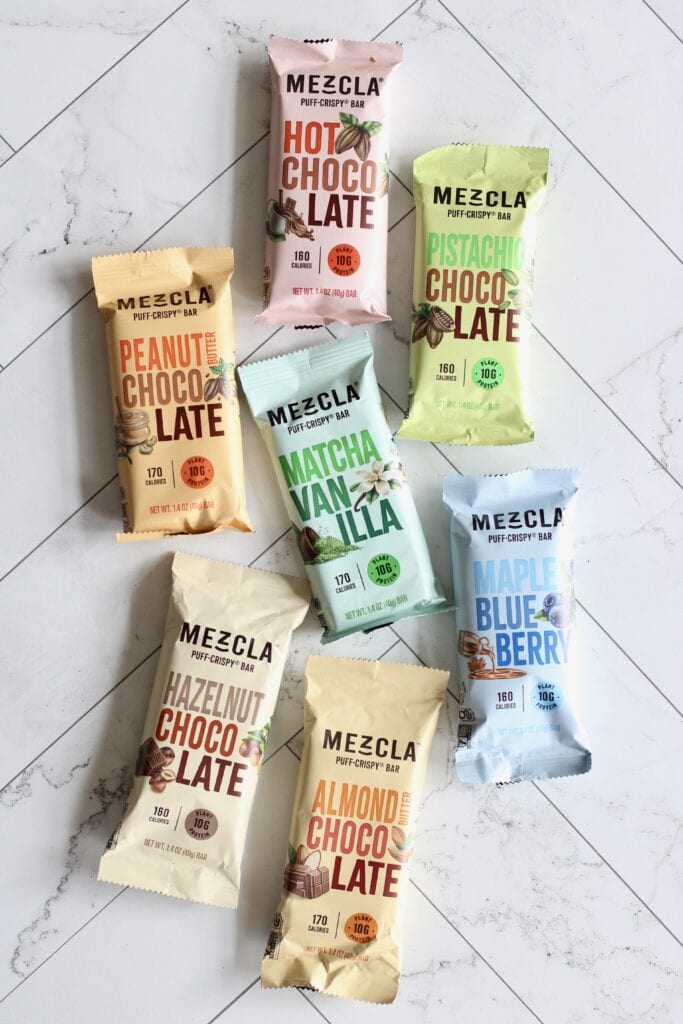 Overhead view of a variety of mezcla bars on a white marble countertop.