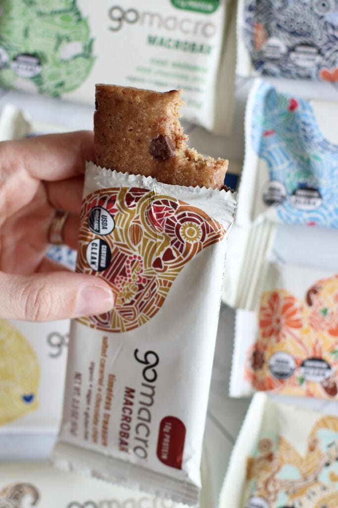 Close up view of a go macro protein bar with a bite out of the top to show the texture of the bar.