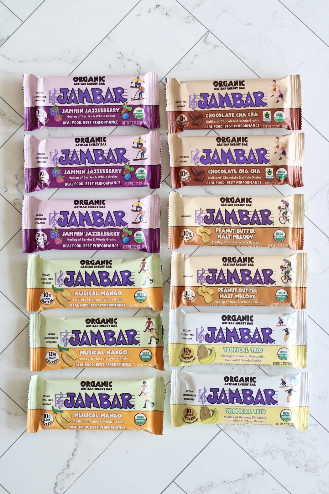 Overhead view of a variety of Jambars arranged on a white marble countertop.
