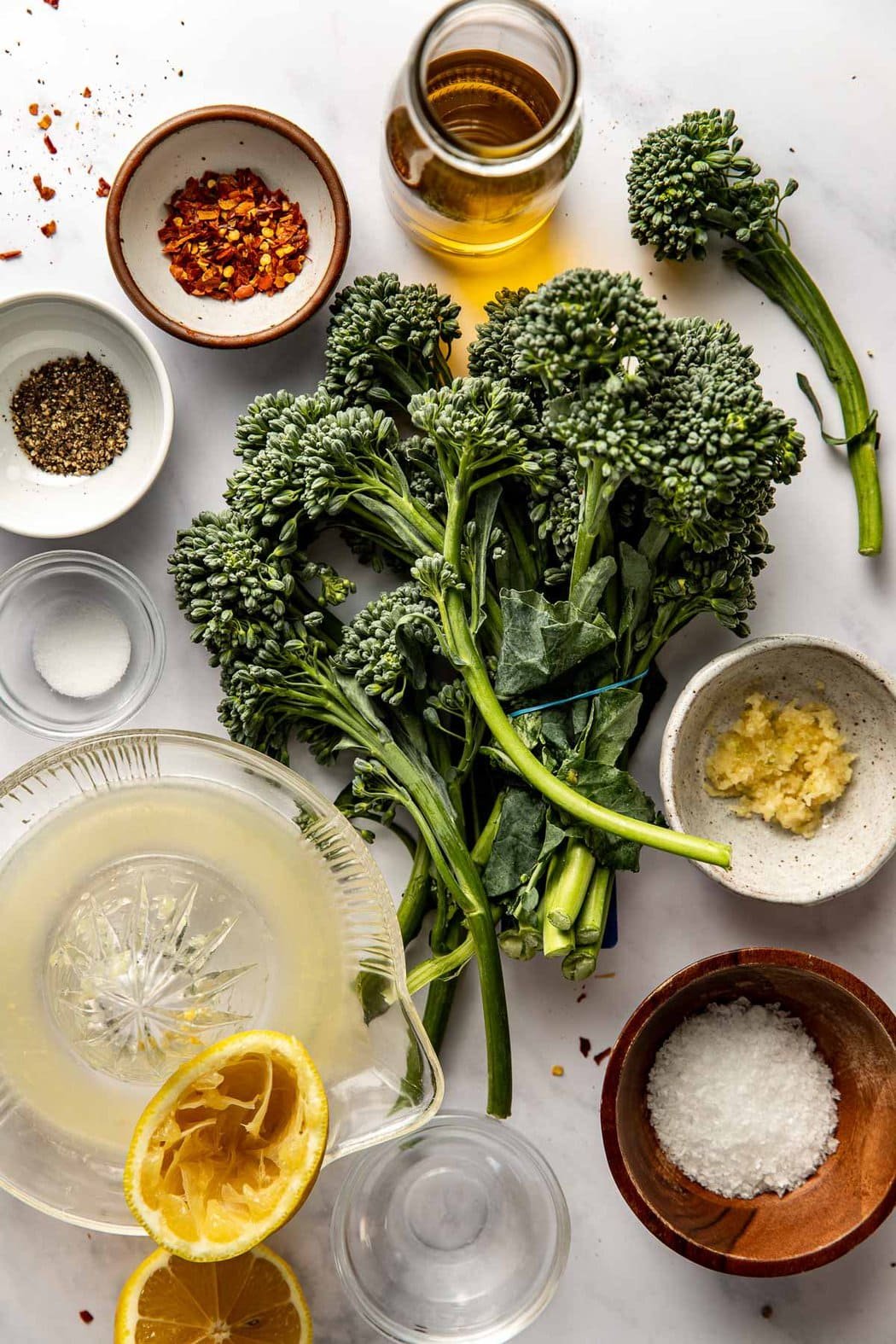 Overhead view of a variety of ingredients for Easy Sauteed Broccolini Recipe in different sized bowls. 