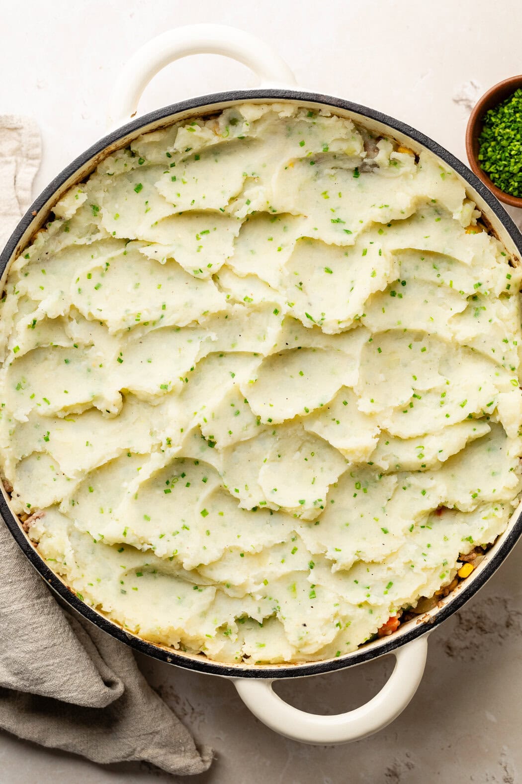 Overhead view of a skillet of Cottage Pie With Garlic Mashed Potatoes ready for baking. 