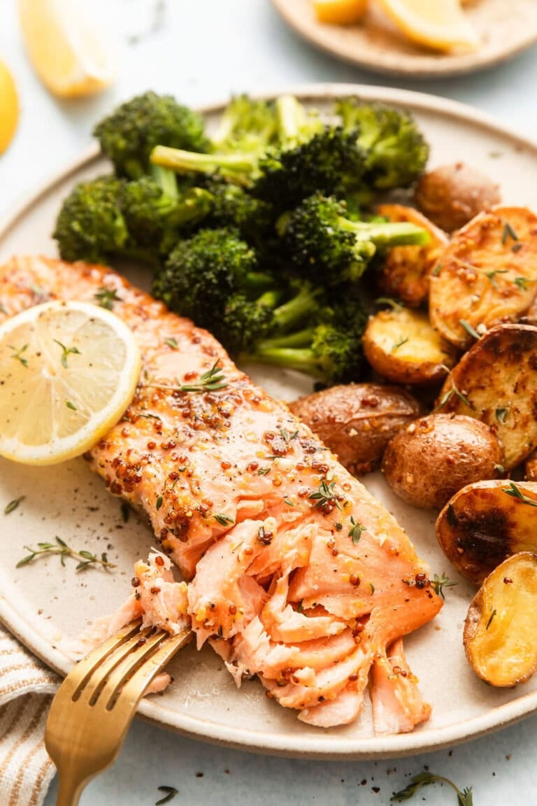 A plate of Sheet Pan Honey Mustard Salmon, broccoli, and baby potatoes. 