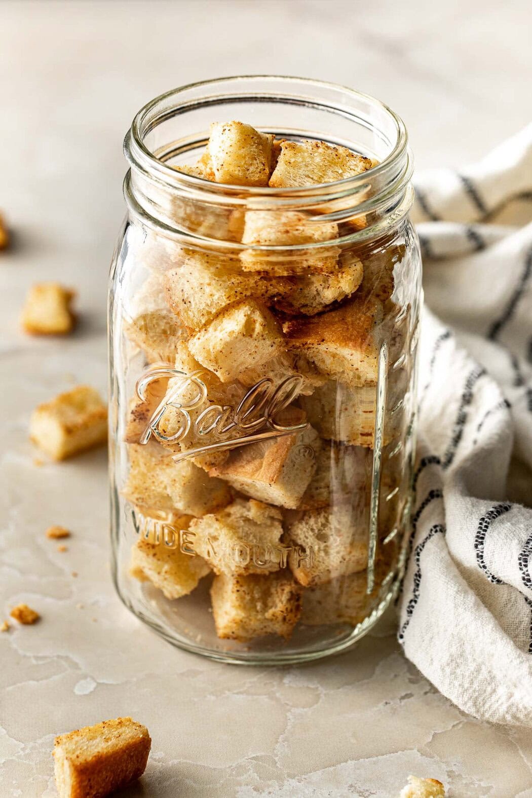 Close up view of a mason jar filled with Homemade Croutons