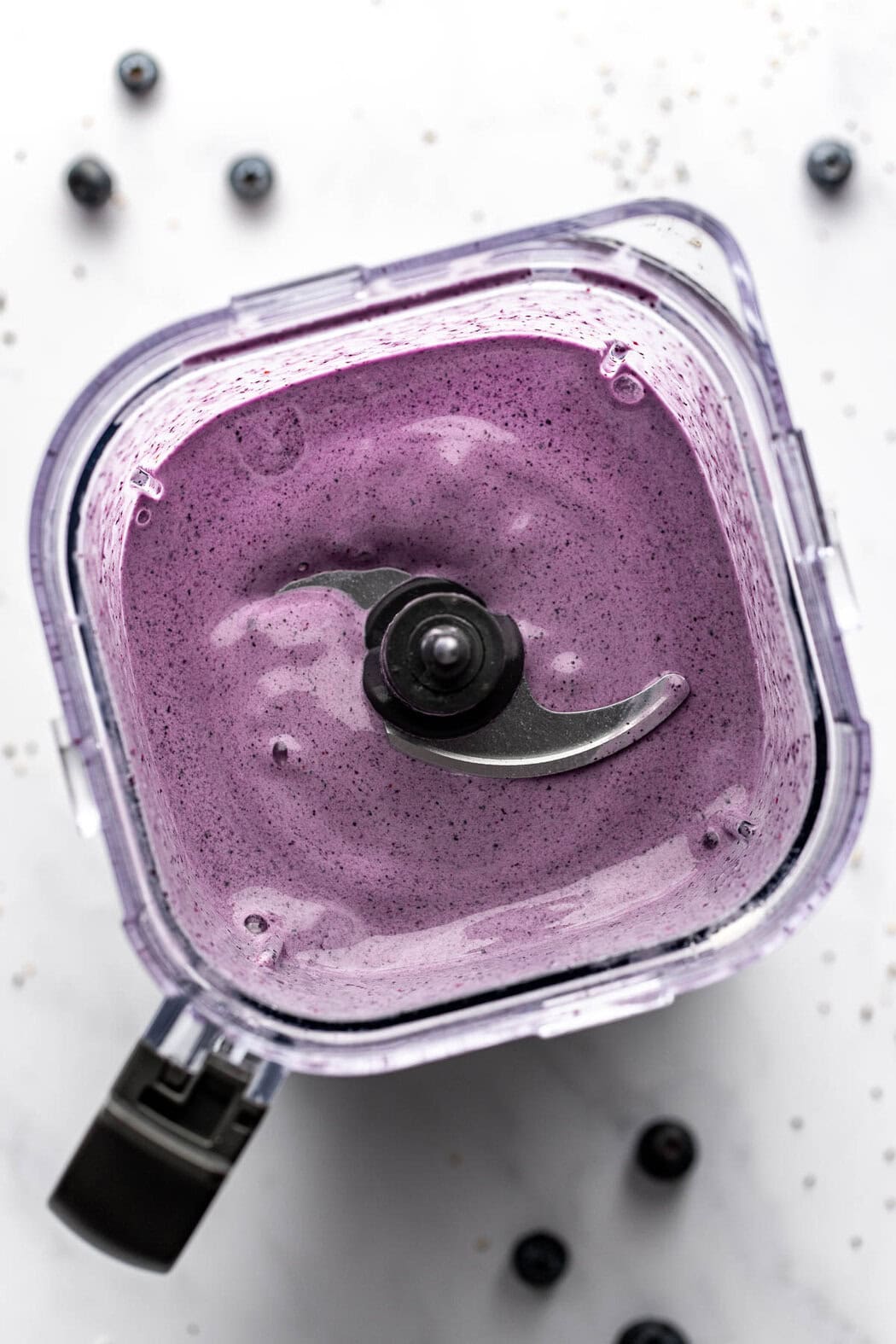 Overhead view of a blender filled with a freshly blended blueberry post workout smoothie.