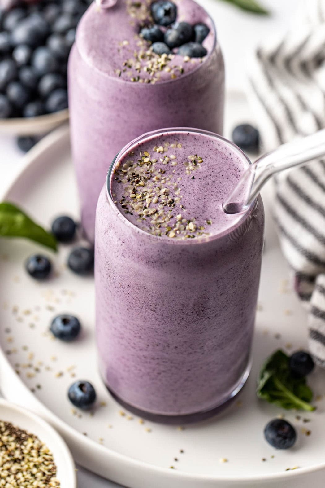 Close up view of two deep purple Post Workout Smoothies topped with hemp seeds. 