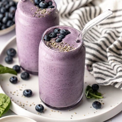 Overhead view of two deep purple Post Workout Smoothies in glasses sprinkled with hemp seeds on top