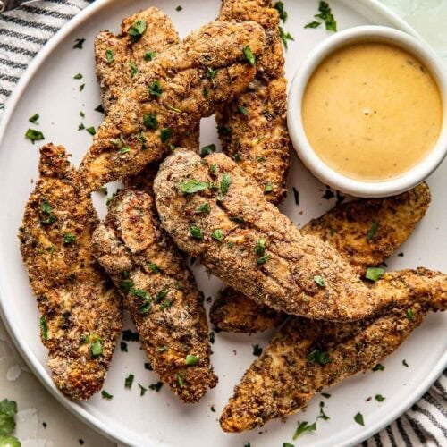 Overhead view of a plate of Air Fryer Chicken Tenders with a side of honey mustard.