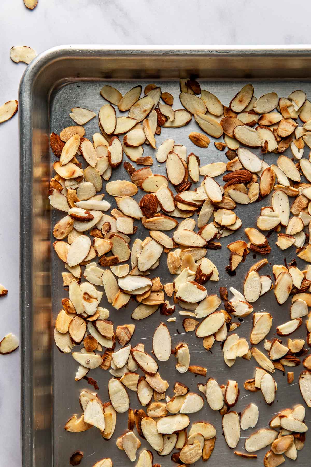 Close up view of a sheet pan of toasted sliced almonds 