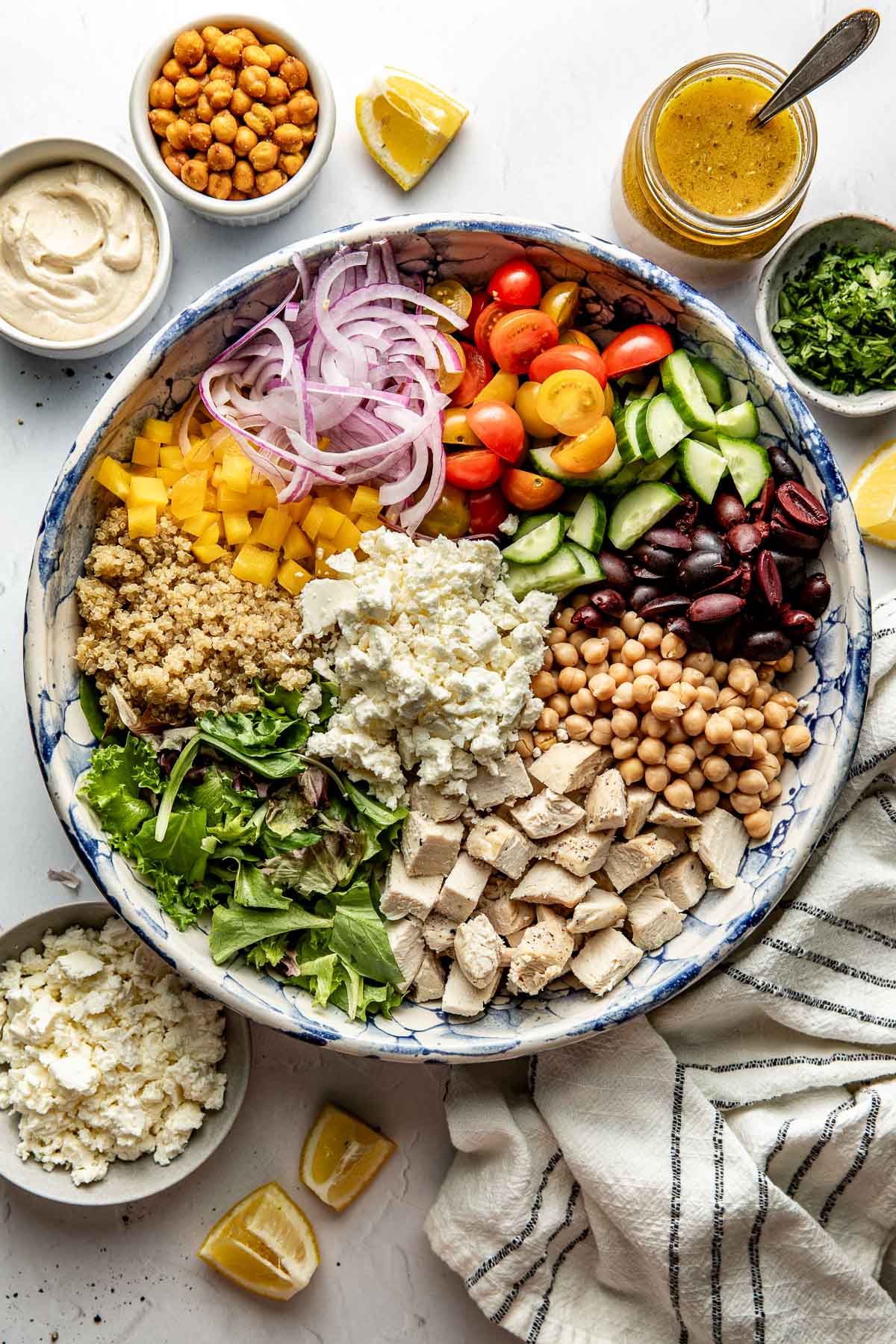 Overhead view of a bowl filled with Chopped Mediterranean Salad ingredients in sections ready for stirring. 