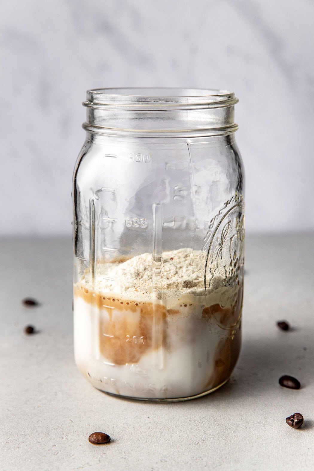 Close up view of a mason jar filled with Protein Coffee ingredients ready for mixing. 
