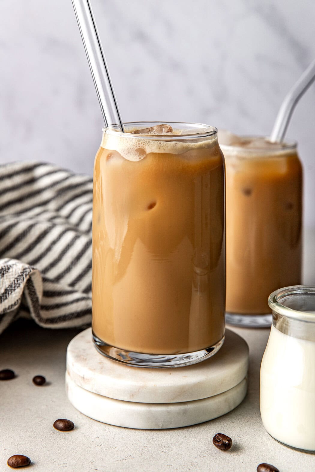 Close up view of 2 glasses of Protein Coffee in glass cups with glass straws. 