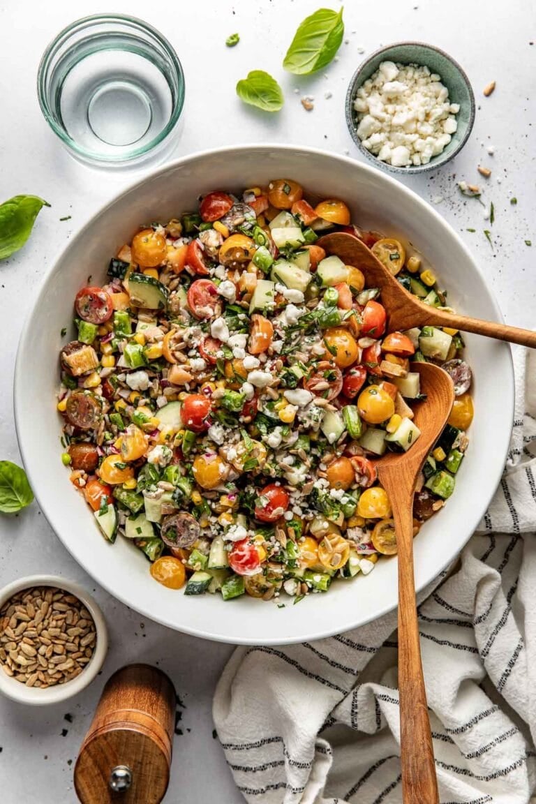 Overhead view white bowl filled with summer salad of fresh produce.