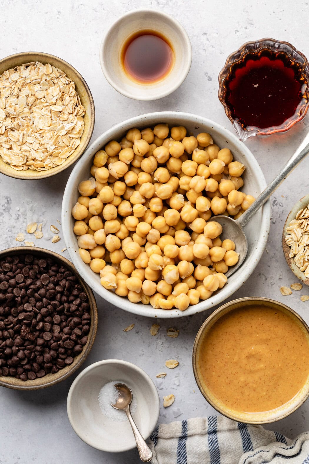 Overhead view of a variety of ingredients for Chickpea Cookie Dough in different sized bowls.