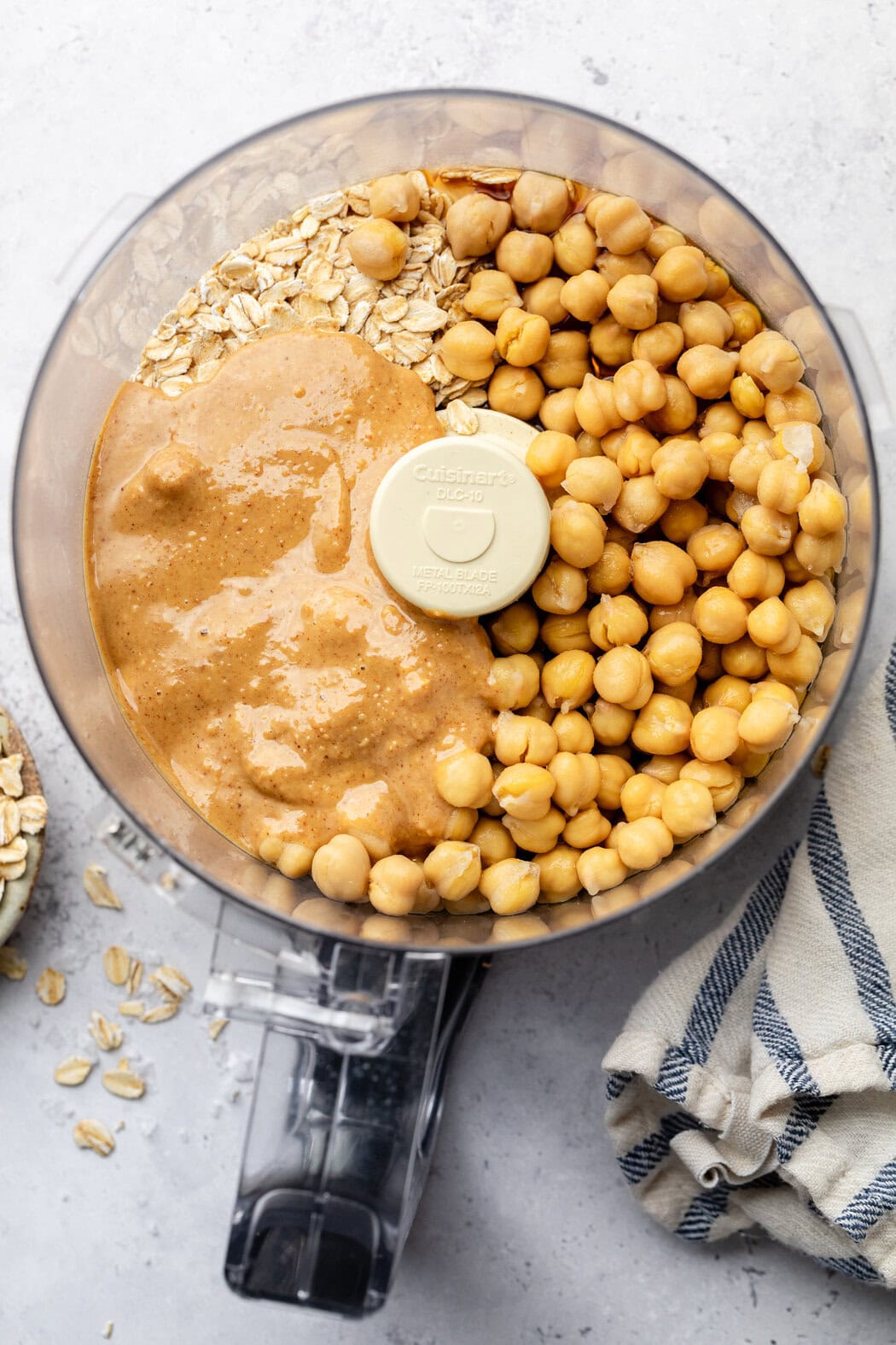 Overhead view of a food processor filled with chickpeas, peanut butter and oats