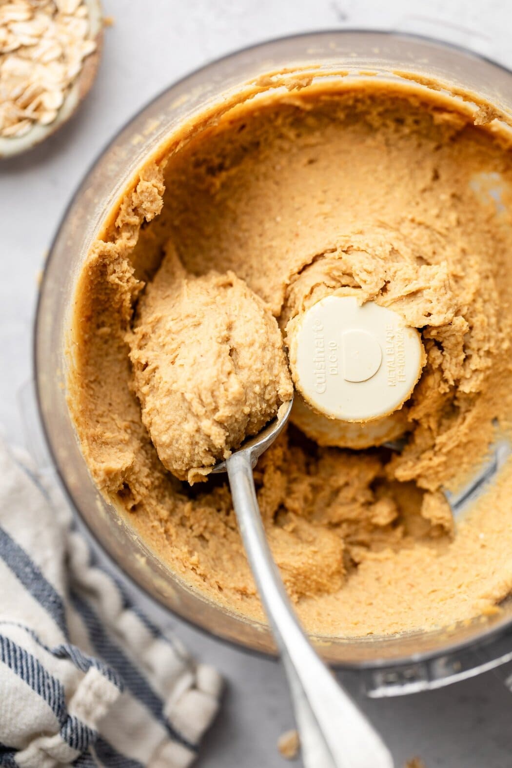 Overhead view of a food processor filled with smooth Chickpea Cookie Dough