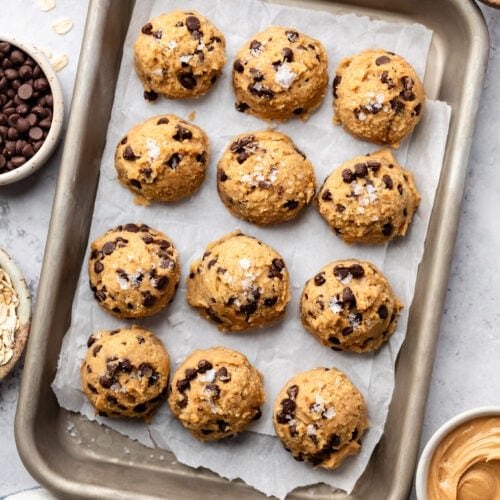 Close up view of a sheet pan of Chickpea Cookie Dough balls topped with flakey sea salt
