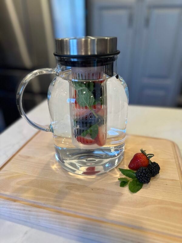 Close up view of a fruit infuser water pitcher.