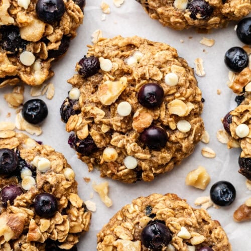 Close up view of a sheet pan of Blueberry Oatmeal Breakfast Cookies to show the soft texture and melted white chocolate chips.