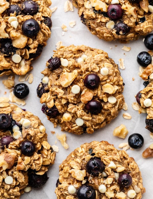 Close up view of a sheet pan of Blueberry Oatmeal Breakfast Cookies to show the soft texture and melted white chocolate chips.