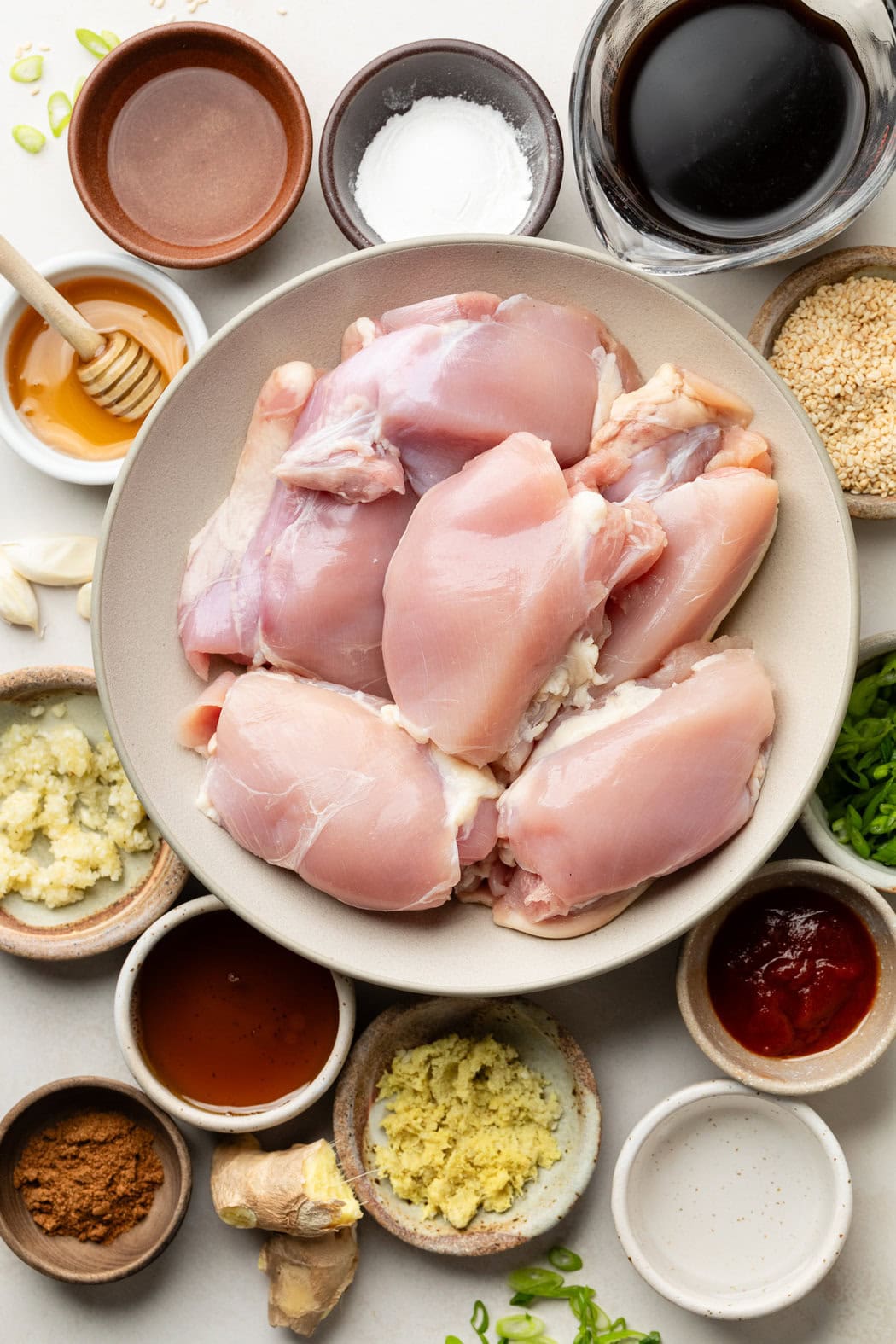 Overhead view of a variety of ingredients for Grilled Korean BBQ Chicken in different sized bowls. 