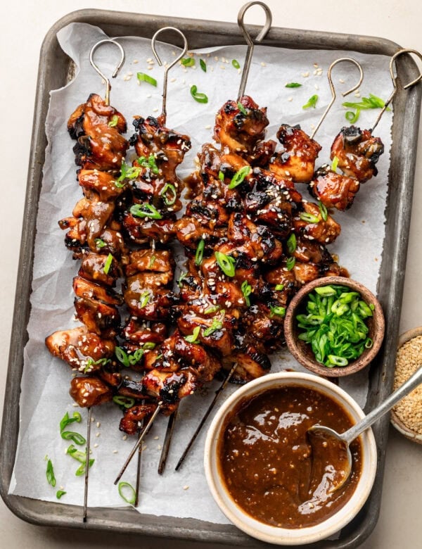 Overhead view sheet pan filled with grilled Korean BBQ chicken on skewers