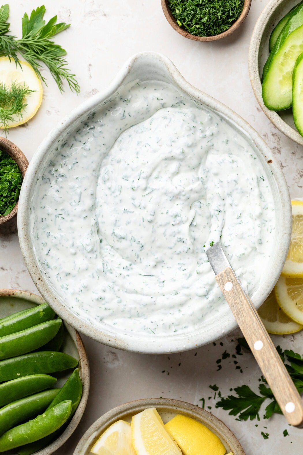 Overhead view of a bowl of whipped cottage cheese dip with a spoon in the bowl. 
