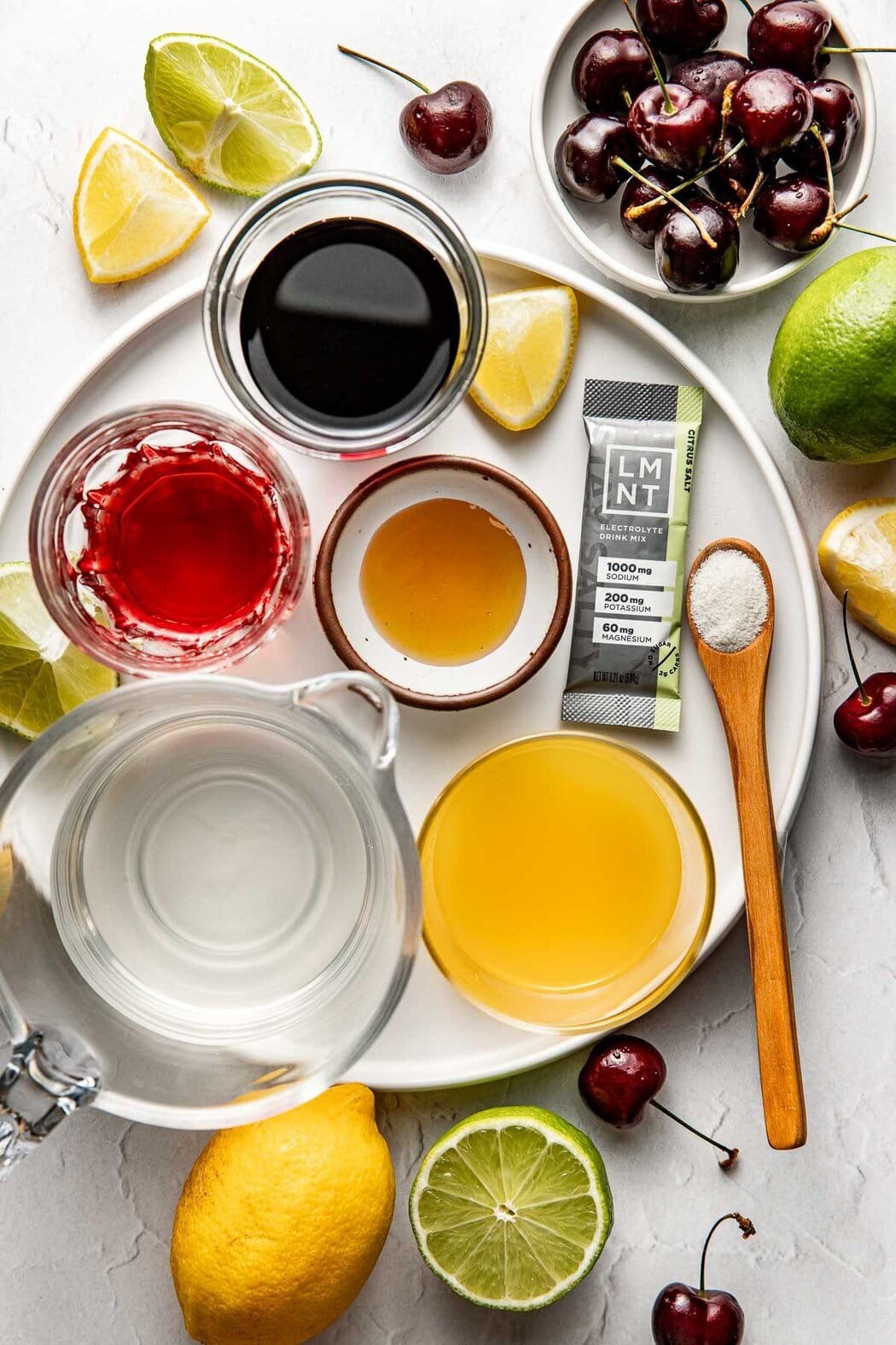 Overhead view of a variety of ingredients for Homemade Gatorade in different sized bowls including fresh fruit.