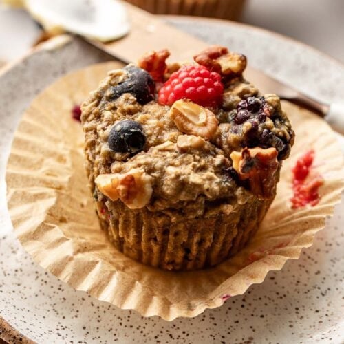 Close up view of a Mixed Berry Baked Oatmeal Muffin topped with walnut pieces.