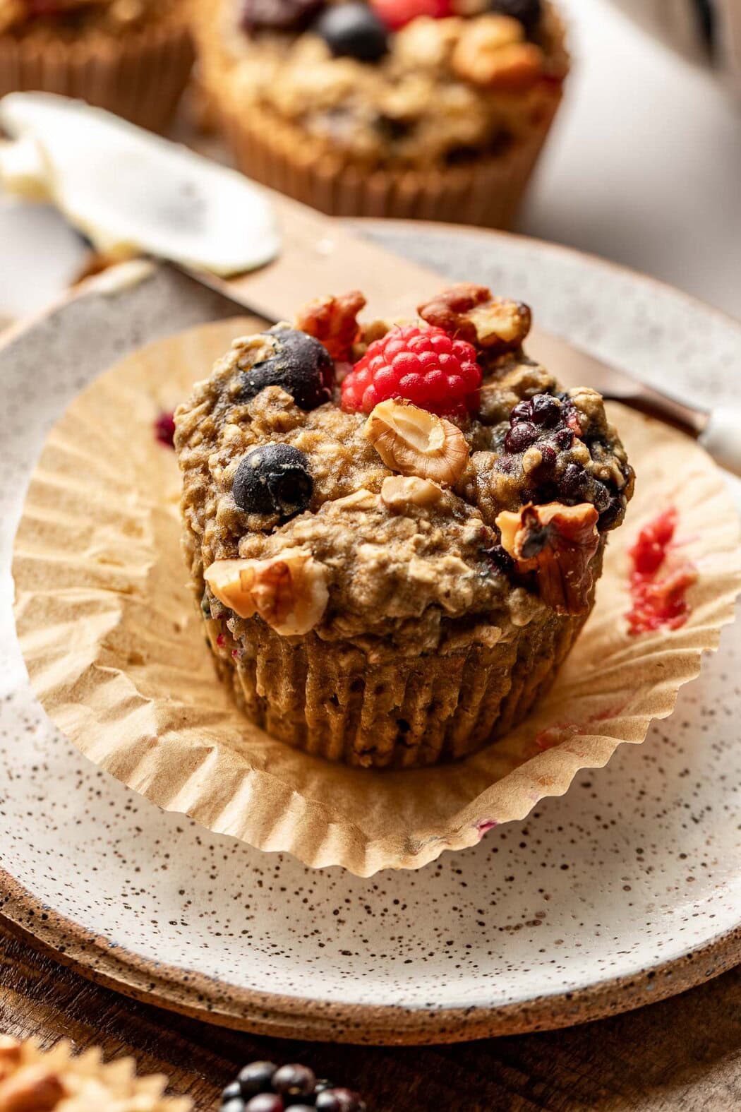 Close up view of a Mixed Berry Baked Oatmeal Muffin with walnuts on top.