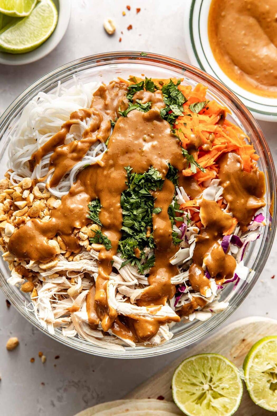 Overhead view of a glass bowl filled with ingredients for Peanut Chicken Wraps ready for stirring. 