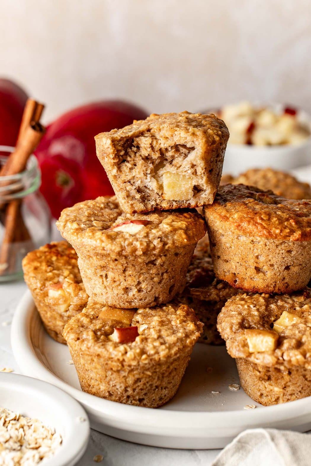 Close up view of a stack of Apple Cinnamon Protein Muffins on a plate showing texture and apple pieces in each muffin. 