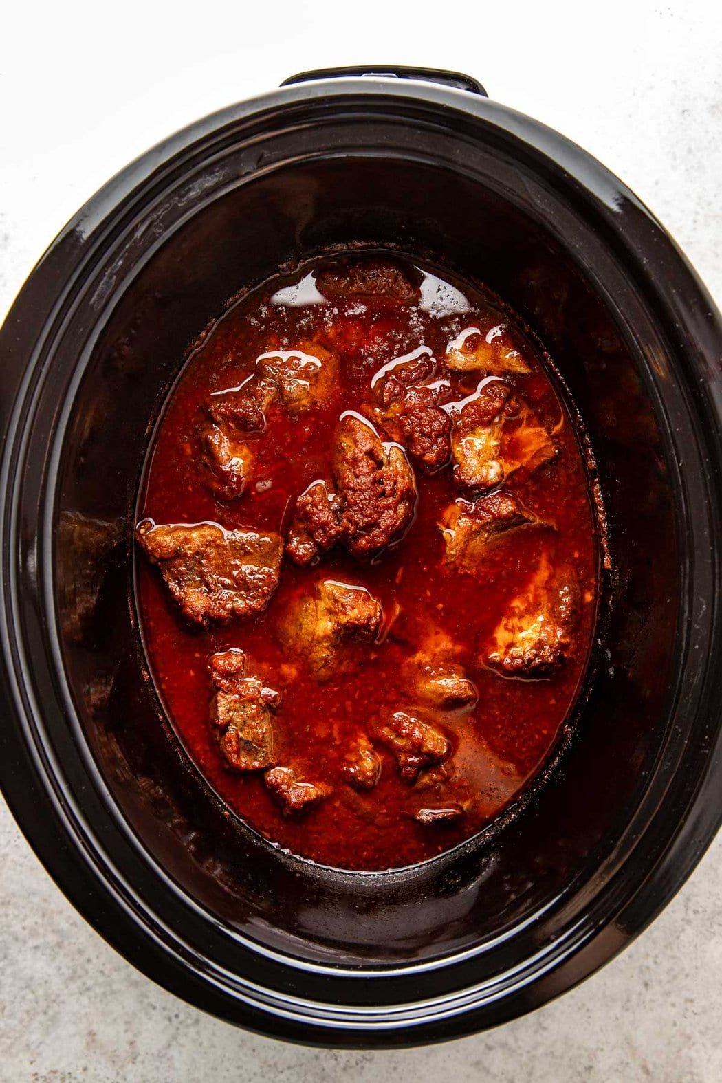 Overhead view of finished Crockpot Tacos Al Pastor ready to be stirred and shredded. 
