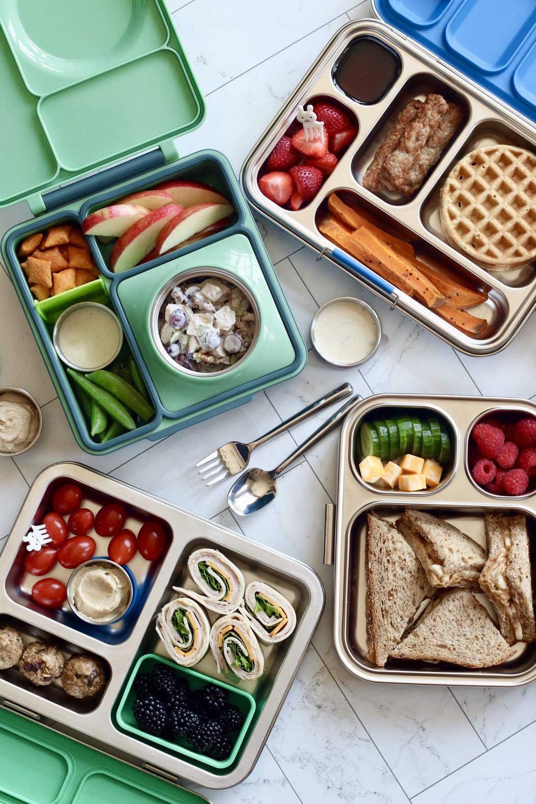 Overhead view of a variety of different lunch boxes filled with nutritious and colorful snack options. 