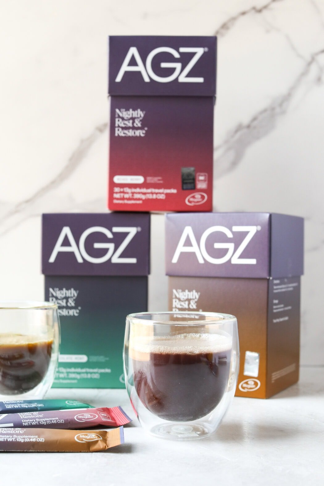 Close up view of two mugs of AGZ mix with boxes in the background. 
