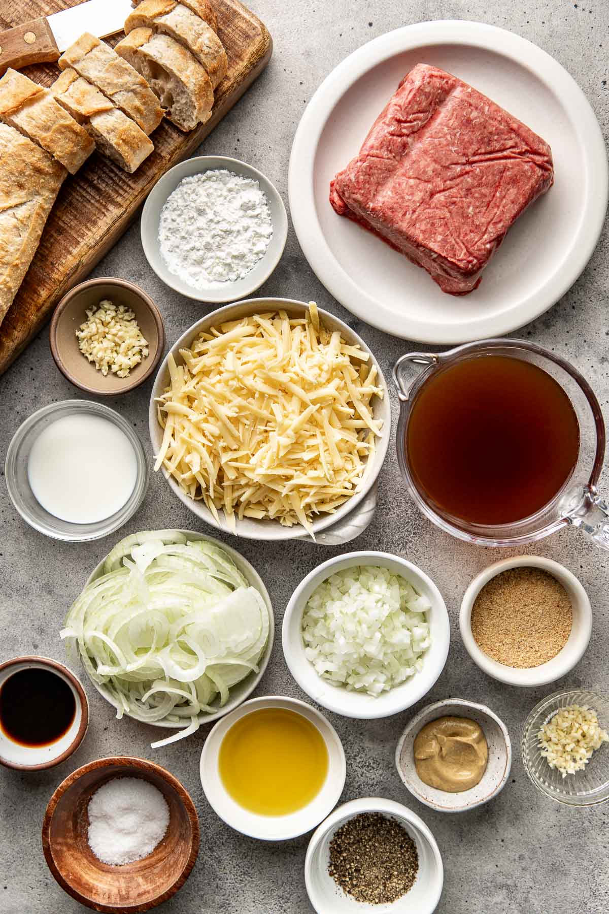 Overhead view of a variety of ingredients for French Onion Meatballs in different sized bowls. 