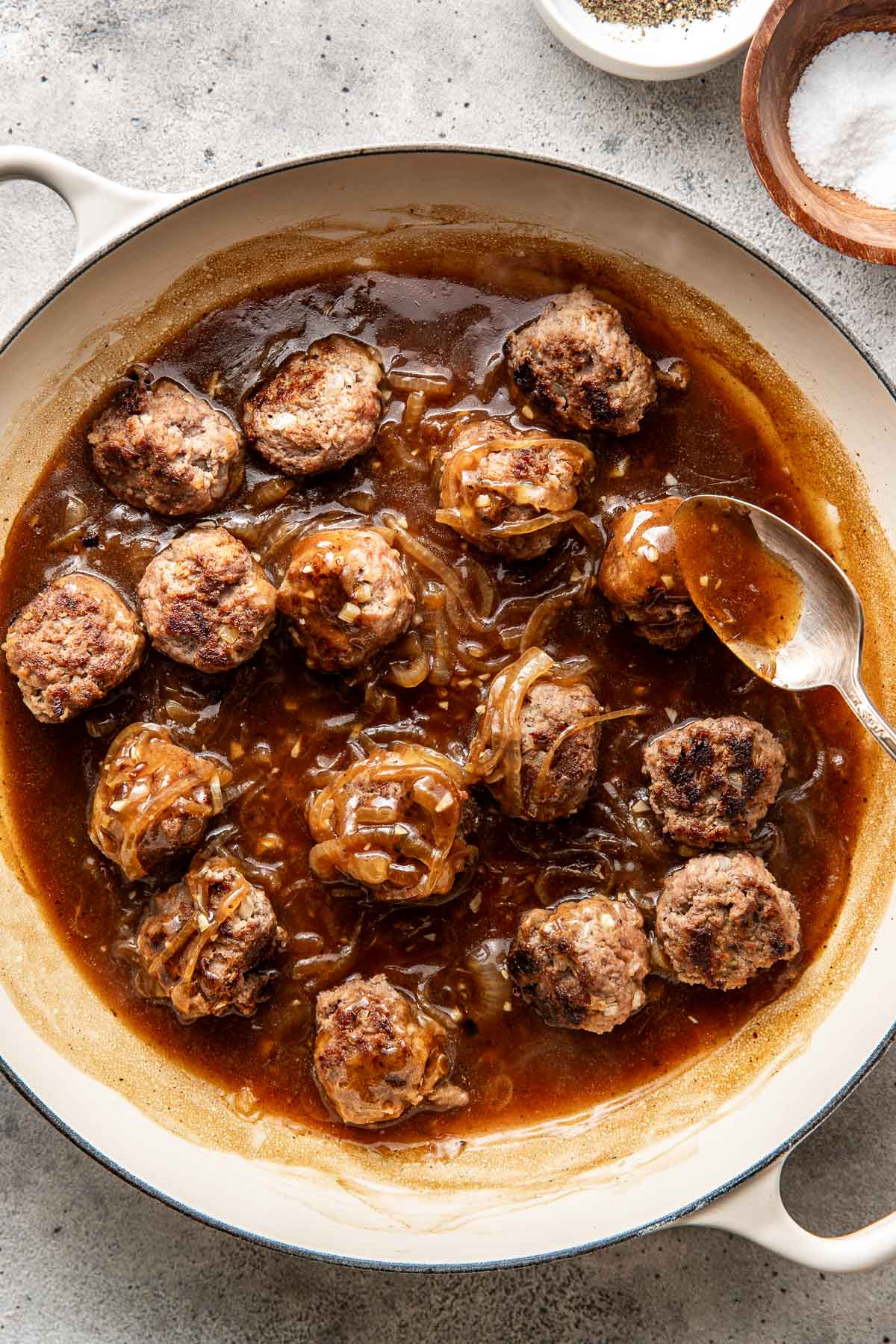 Overhead view of a skillet filled with freshly fried French Onion Meatballs surrounded by brown gravy